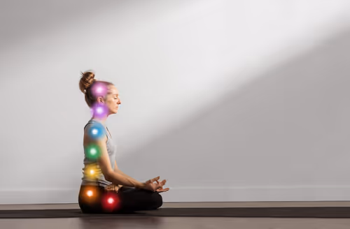 femme en position de méditation avec lumière illustrant les 7 chakras
